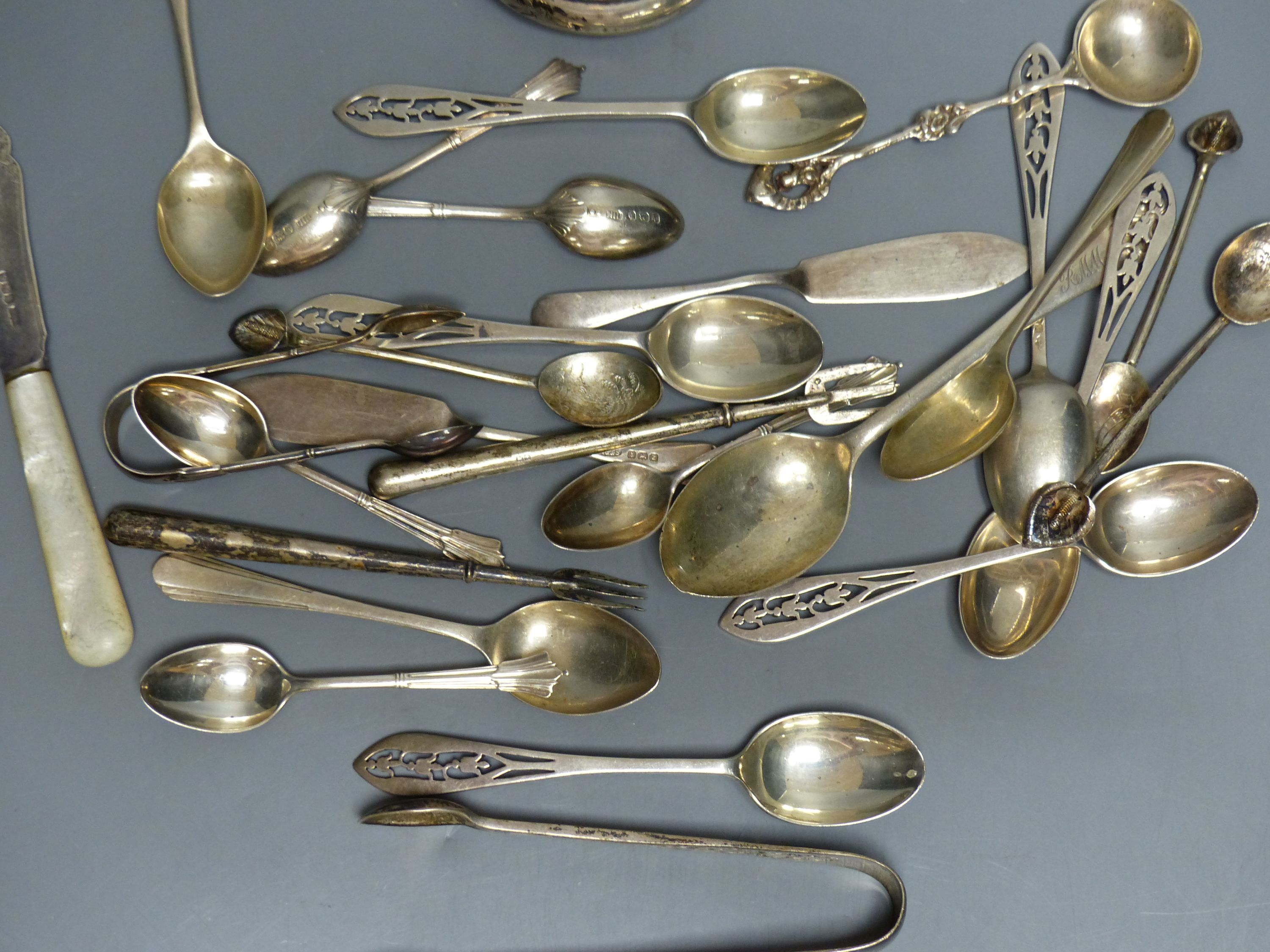 A set of six silver teaspoons and sugar tongs with pierced finials, various other silver spoons, butter knives, etc. (approx 10oz)